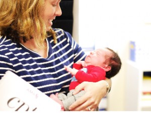 Woman smiling and holding newborn baby